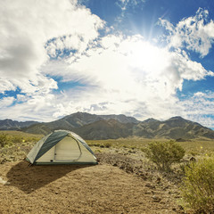 Camping tent in a wild remote nature park area of desert and mountain trails
