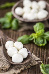 Small Mozzarella balls (on wooden background)
