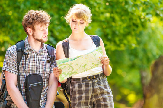 Hiking backpacking couple reading map on trip.