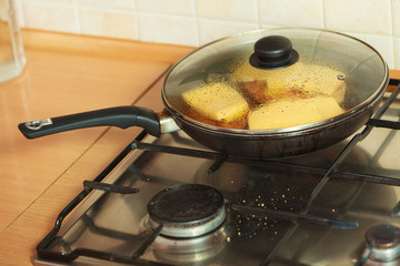 Frying chicken cutlet with pineapples and cheese.