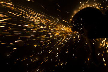 Glowing flow of steel metal spark dust particles and bokeh shine in the dark background
