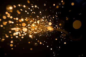 Fotobehang Glowing flow of steel metal spark dust particles and bokeh shine in the dark background   © tannujannu
