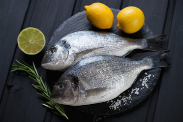 Raw fresh dorado with seasonings on a stone slate tray