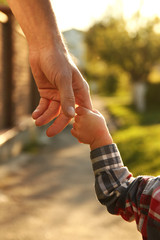the parent holds the hand of a small child