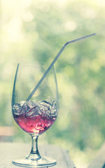 Glass of sweet red drink in the summer sunny day