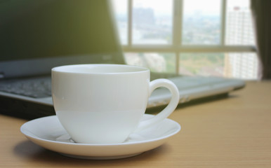 Cup of coffee on the wooden floor and Blurred bedroom window bac