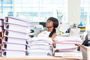 Businesswoman sleeping in office with many work