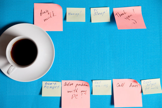 Cup of coffee and stickers with reminders on a blue background