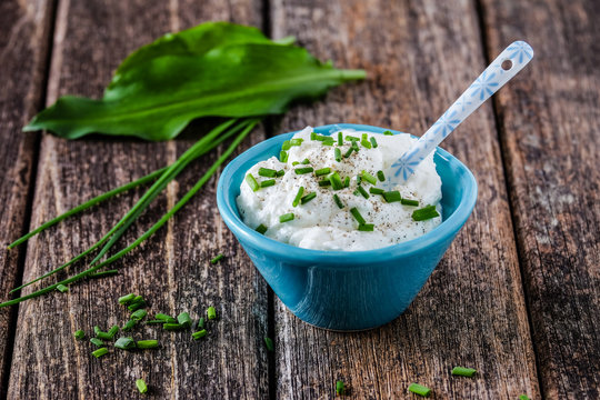 Skyr Kr&auml;uterquark in blauer Schale auf Holz