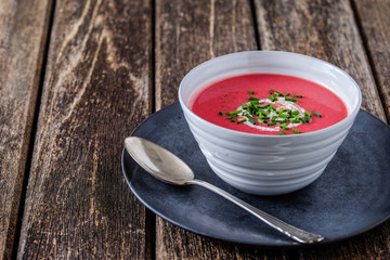 Rote-Bete-Suppe in weißer Schale auf Holz