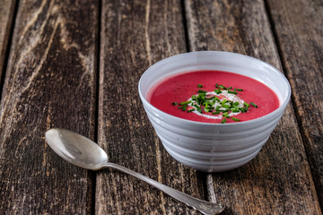 Rote-Bete-Suppe in weißer Schale auf Holz