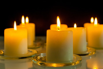 closeup to burning candles in darkness