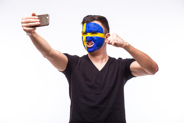 Selfie on phone of Swede football fan in game supporting of Sweden national teams on white background. European football fans concept.