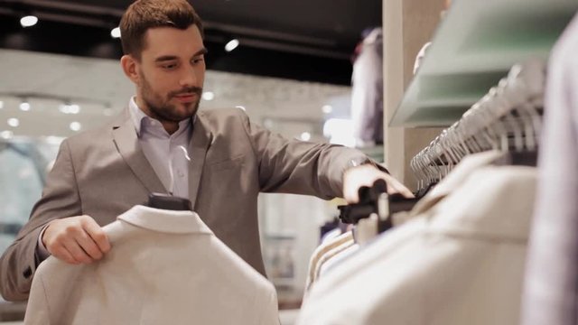 young man choosing clothes in clothing store