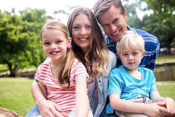 Happy family sitting together in the park