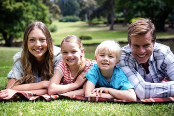 Fototapeta premium Happy family lying in the park