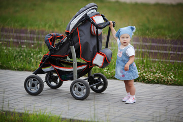 little funny girl with baby carriage