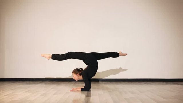 Flexible girl doing forearm stand split and scorpion pose
