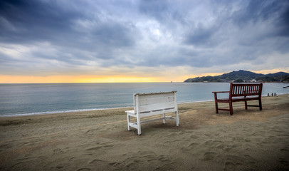 夕暮れのビーチとベンチ