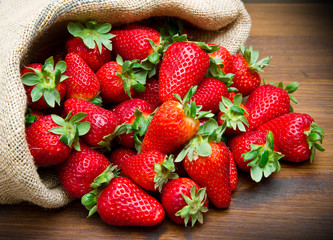 fresh strawberry in burlap sack on wood - 109299881