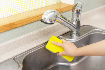 流し台を掃除する女性