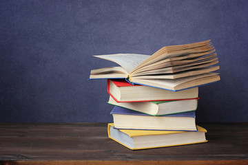 A stack of books on the table. An open book.