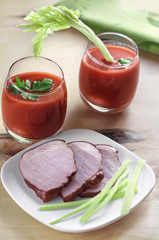 Meat on a plate and tomato juice in glass