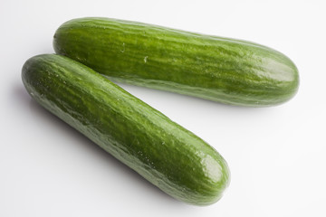 Two whole big cucumbers on white background