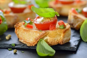 Foto auf Acrylglas Vorspeise Überbackene Brötchen mit Tomaten, Mozzarella, Olivenöl und Basilikum, mit grünem Pfeffer pikant gewürzt - Hot starters: Crispy baked crostini with tomato, mozzarella, olive oil, garlic and basil 