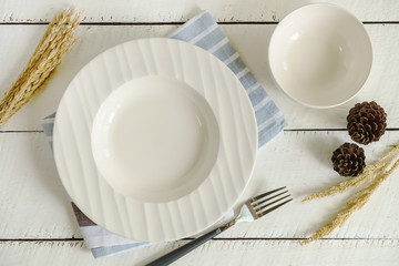 Empty dish setting on white wooden background