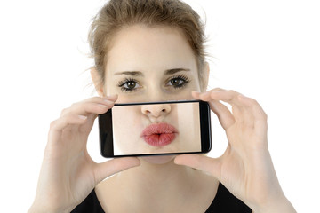 Frau hält Smartphone mit Selfie oder Foto von Kussmund oder Mund vor Gesicht