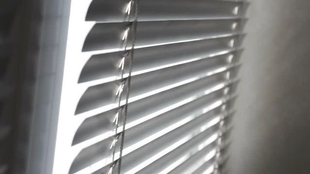 Sunlight coming through venetian blinds by the window