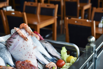 Different kind of fishes and shrimps are in a seafood restaurant.