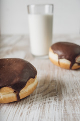 Donuts with chocolate frosting and a glass of milk