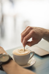 Close up of young man drinking coffee at the coffee shop