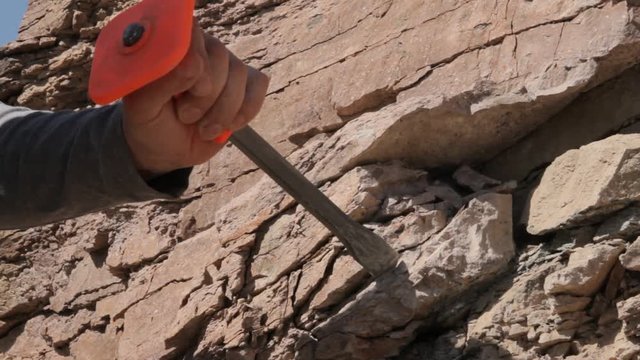 man destroys bedrock using a hammer and chisel
