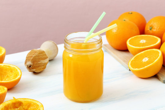 succo di frutta spremuta di arancia in barattolo di vetro sfondo colorato
