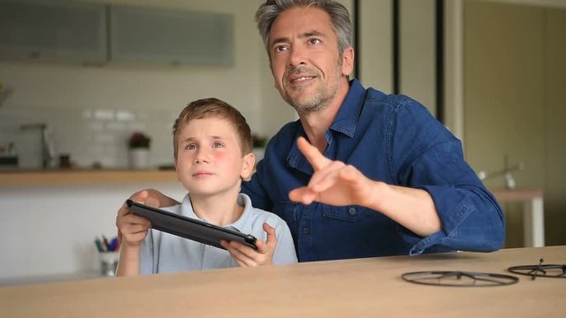 Dad and son playing with toy drone