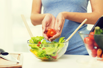 close up of woman cooking vegetable salad at home