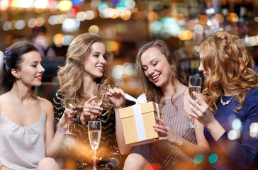 happy women with champagne and gift at night club