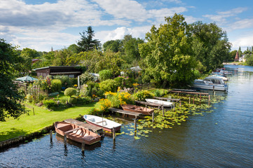 Idyllischer Schrebergarten am Kanal. Bootsanleger, viele Boote.