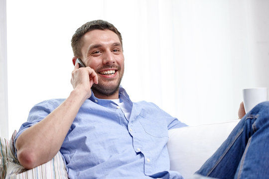 smiling man with smartphone at home