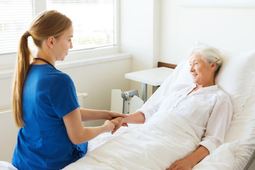 doctor or nurse visiting senior woman at hospital