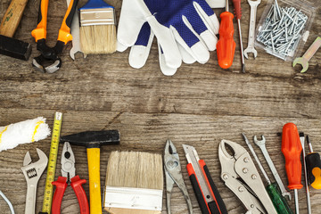 Assorted work tools on wood background