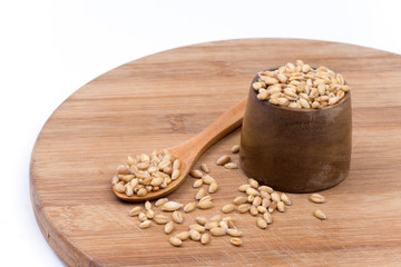 Wooden spoon with a bowl of wheat grains