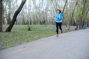Fototapeta premium Young woman in black tights running around the Park