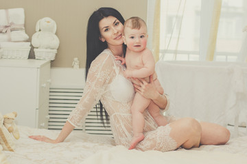 Happy mother with naked baby at home