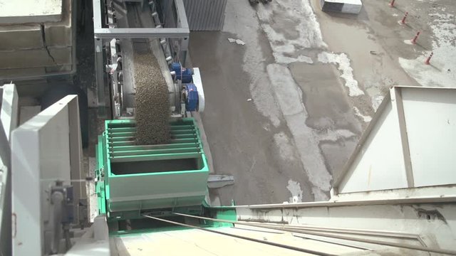 Large amounts of sand falling from conveyor belt onto automatic operated bucket. Separation sand for construction industry. Ground,gravel, sand, stones  separation process, sand refinement. 