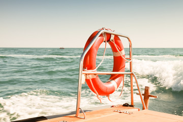 Bright red lifebuoy hanging on stern railings