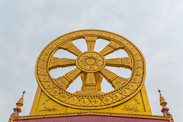 Golden Wheel of Dhamma on sky clouds (Dharmachakra ) Thai Art in public temple
Wheel of Dhamma symbol of Buddhism